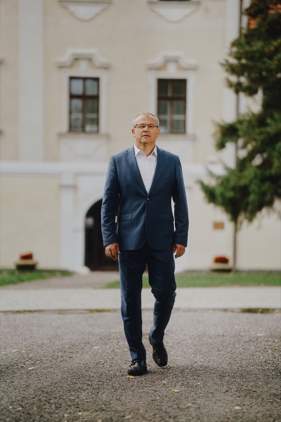 Jaroslav Mareček kráča po nádvorí pred historickou budovou